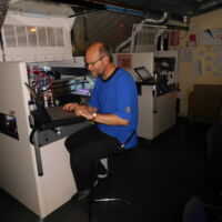Jan bezig met instellen van een Nordson vernismachine.